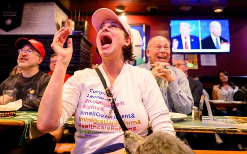 Customers react during the televised debate between Joe Biden and Donald Tump, in a pub in