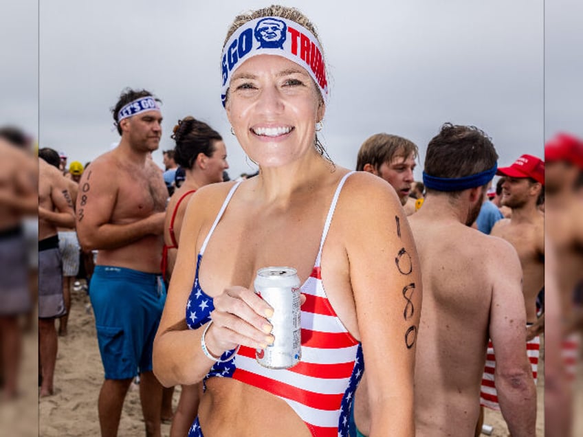 HERMOSA BEACH, CALIFORNIA - JULY 4: A woman with a "Lets Go Trump" headband, hol