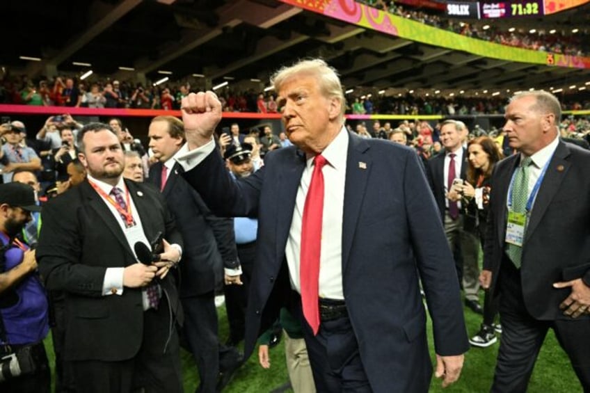 US President Donald Trump salutes the crowd from the field at the New Orleans Superdome at