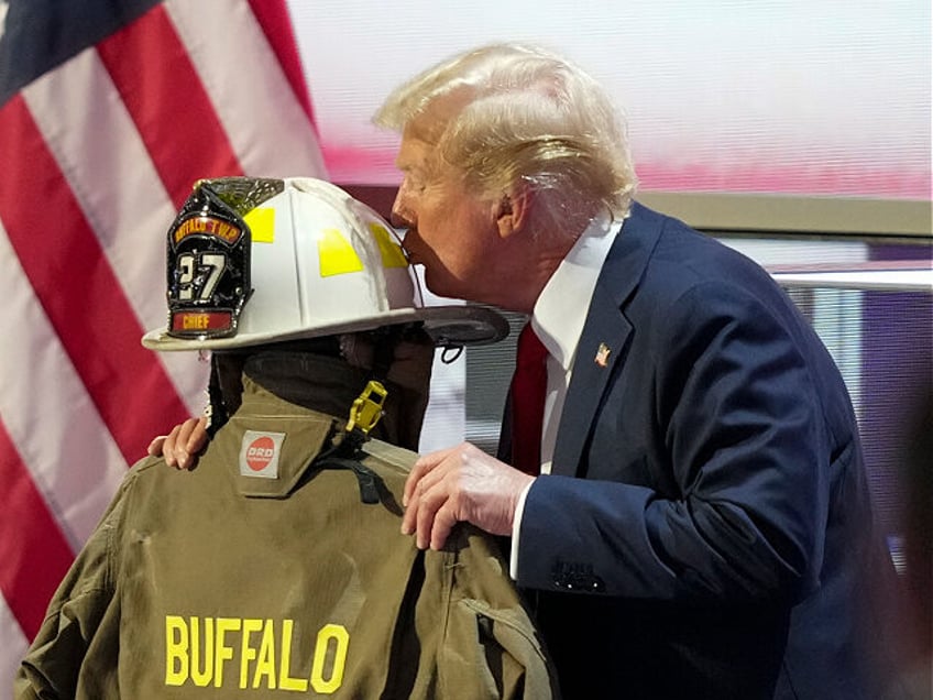 Republican presidential candidate former President Donald Trump kisses the helmet of Corey