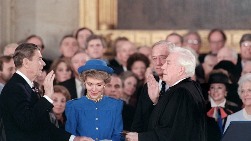 Reagan, left, is sworn in as 40th President of the United States by Chief Justice Warren Burger, right beside his wife Nancy Reagan, center, during inaugural ceremony, on January 21, 1985 in the Capitol Rotunda.