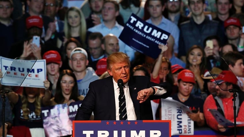 US Republican Presidential candidate Donald Trump checks his watch to see if it is election day as he addresses the final rally of his 2016 presidential campaign at Devos Place in Grand Rapids, Michigan on November 7, 2016. / AFP / JEFF KOWALSKY        (Photo credit should read JEFF KOWALSKY/AFP via Getty Images)