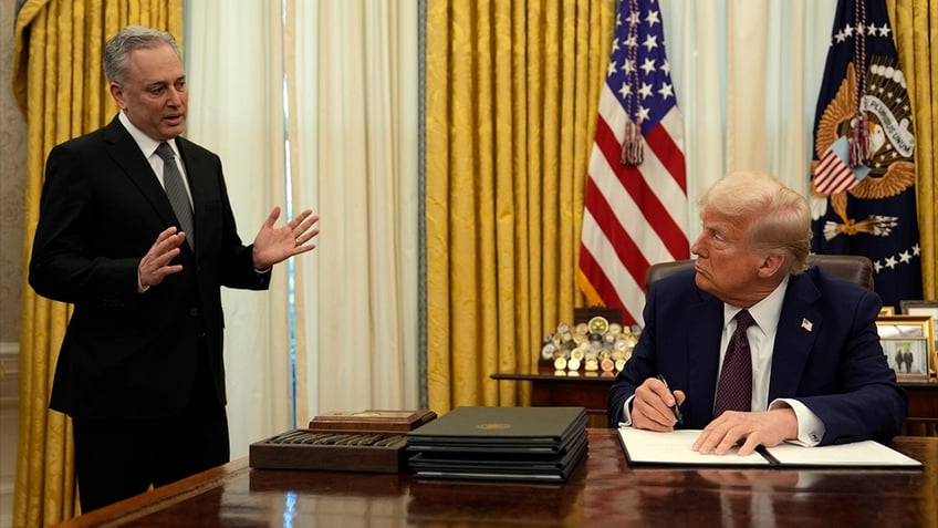 Trump at desk signing document, David Sacks on left of photo