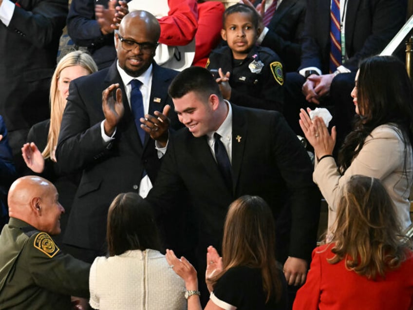 Jason Hartley (C) stands after US President Donald Trump announced that Hartley has been a