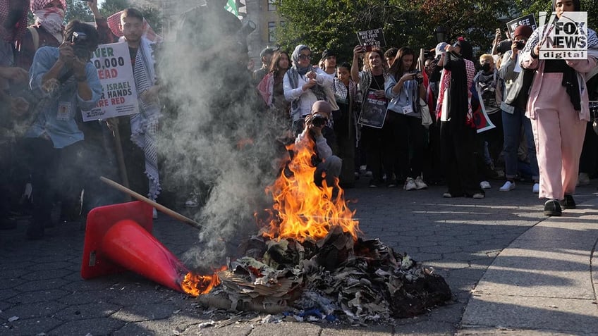 A pile of trash burns at a pro Hamas rally