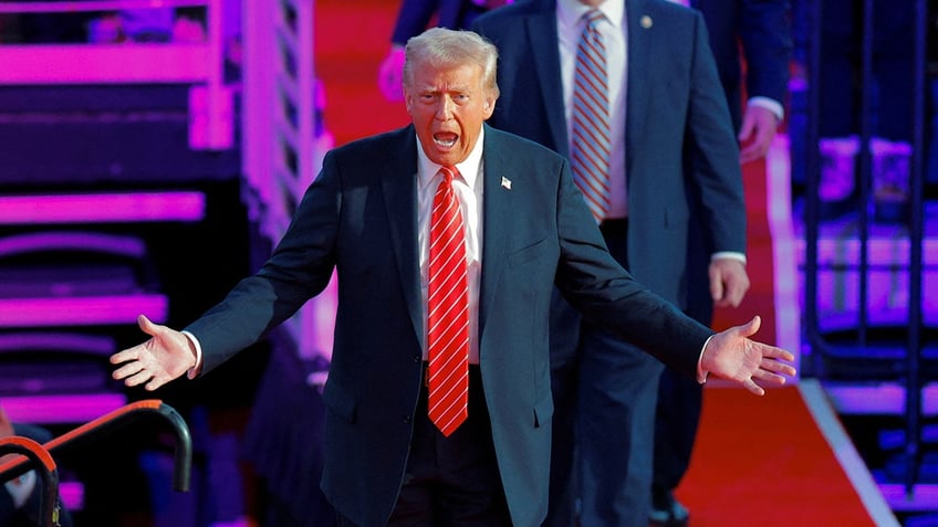 Donald Trump reacts as he takes the stage during a rally the day before he is scheduled to be inaugurated