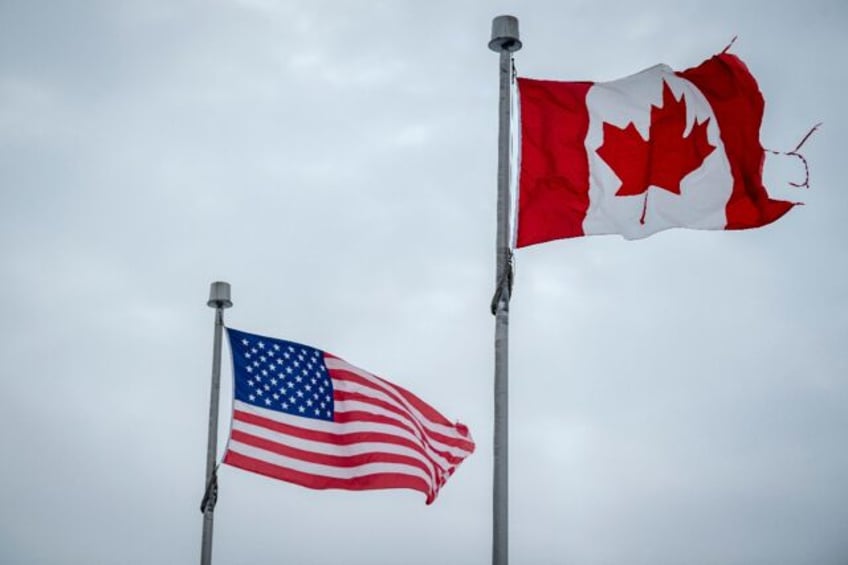 The Canadian and US flags fly near the countries' border in Blackpool, Quebec, Canada