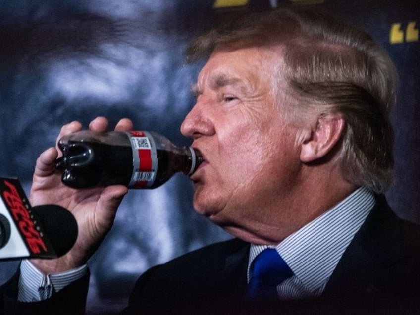 Former US President Donald Trump drinks a soda as he hosts the Holyfield vs Belford boxing