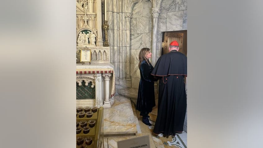 Maria Bartiromo and Cardinal Dolan looking at Jeremy Lai's photo in St. Patrick's Cathedral