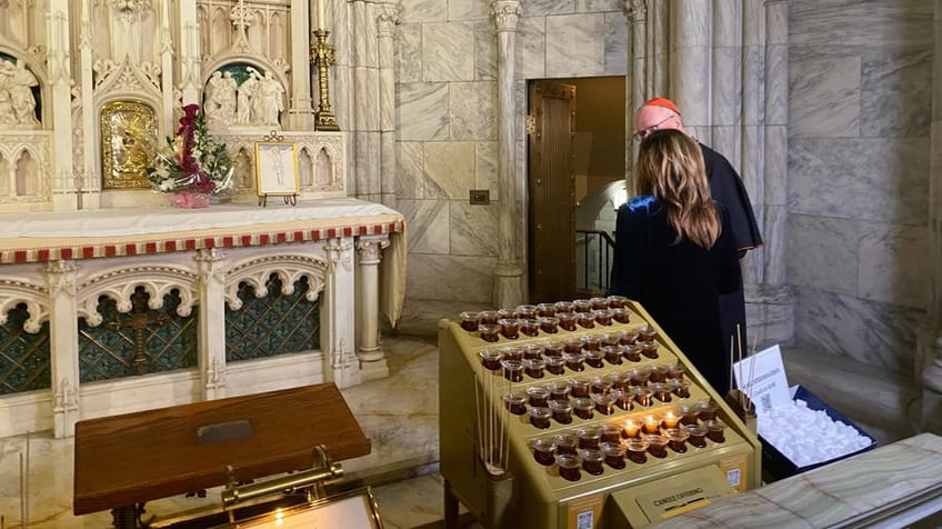 Maria Bartiromo and Cardinal Dolan looking at Jeremy Lai's photo