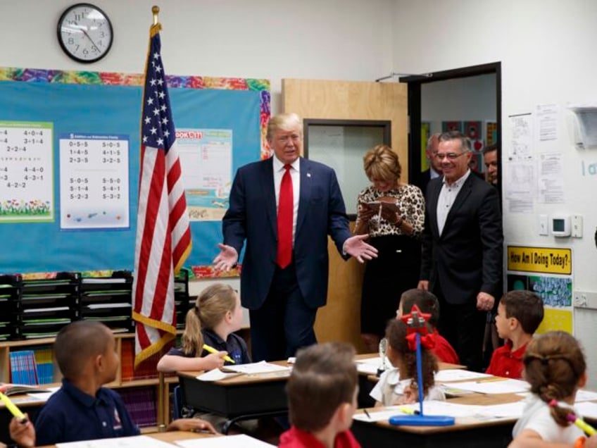 Republican presidential candidate Donald Trump tours a classroom during a visit to the Int