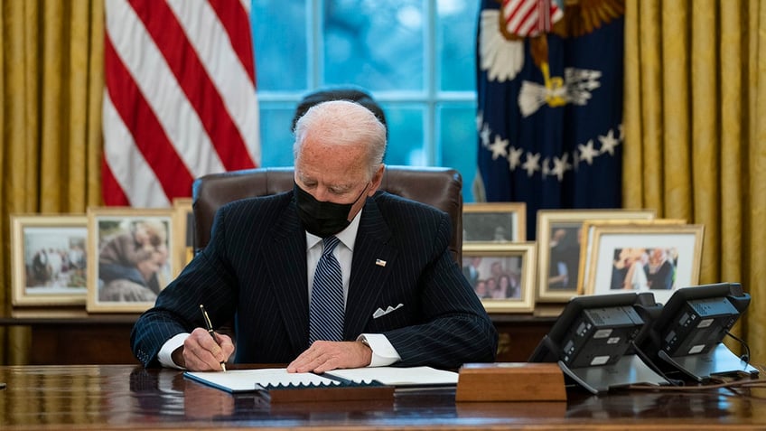 President Joe Biden signs an Executive Order reversing the Trump era ban on transgender individuals serving in military, in the Oval Office of the White House, Monday, Jan. 25, 2021, in Washington.