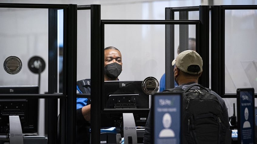 TSA agent screening passenger at airport