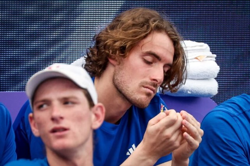 Greece's Stefanos Tsitsipas (R) sits on the team bench after pulling out of singles match at the United Cup