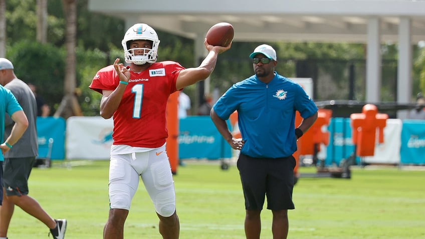 Tua Tagovailoa throws ball with Brian Flores watching