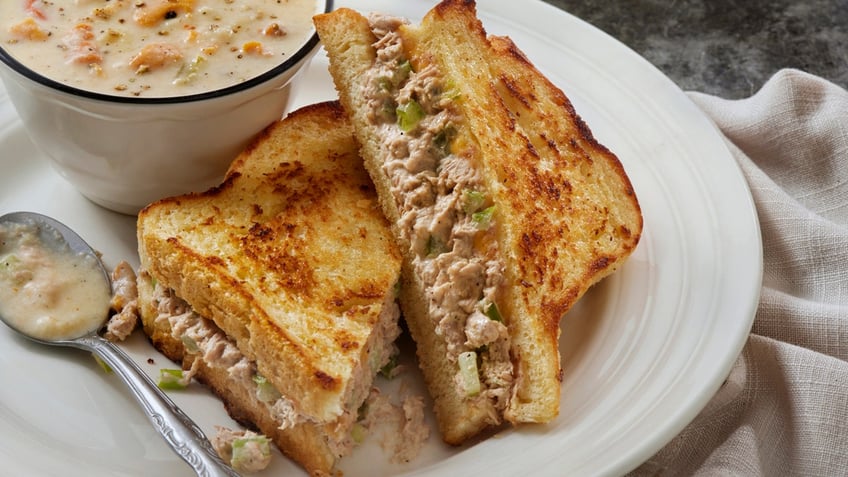 A tuna melt sandwich and bowl of clam chowder are seen.