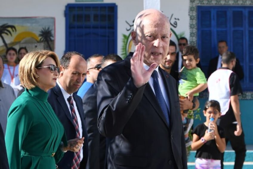 Tunisia's President Kais Saied waves outside a polling station in Tunis after casting his