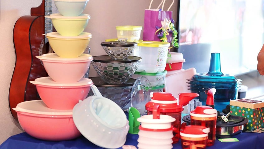 Tupperware items, including a set of "retro" storage containers, rest on a table during a Tupperware party.