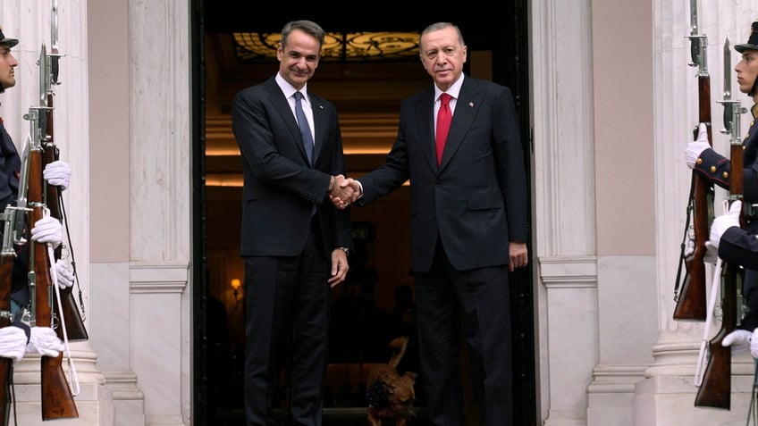 Greece's Prime Minister Kyriakos Mitsotakis, left, welcomes the Turkey's President Recep Tayyip Erdogan, right