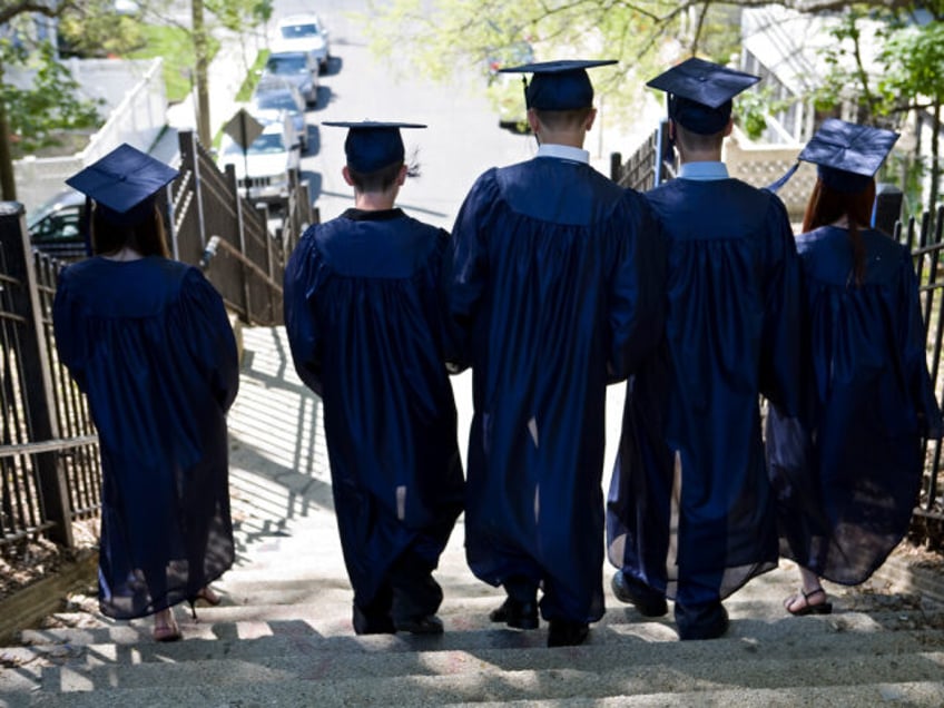 Five students in graduation gowns walking down the stairs.