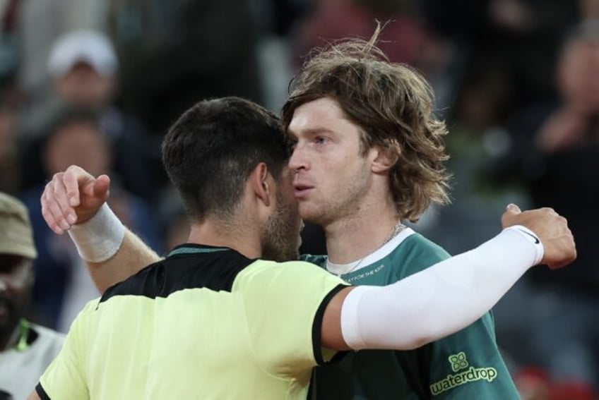 All over: Andrey Rublev (R) embraces Carlos Alcaraz