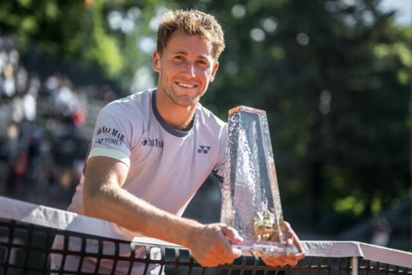 Casper Ruud poses at the net with the Geneva Open title