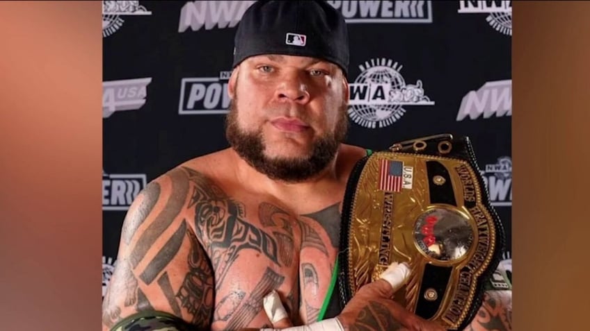 Wrestler Tyrus holding championship belt