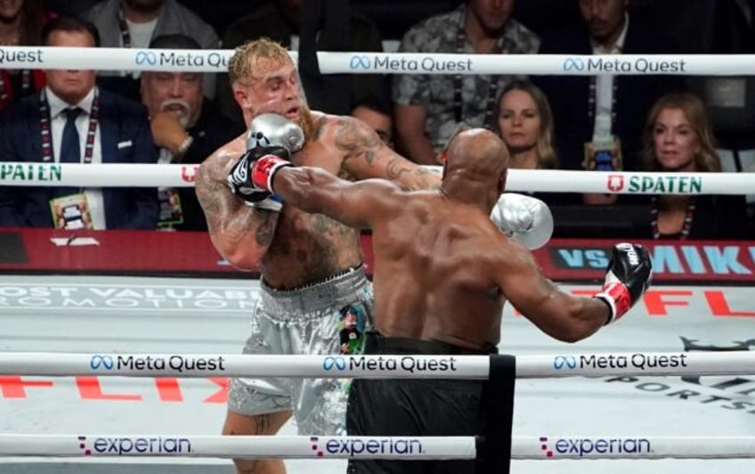 Jake Paul (left) backs Mike Tyson onto the ropes in their eight-round fight in Texas on Fr