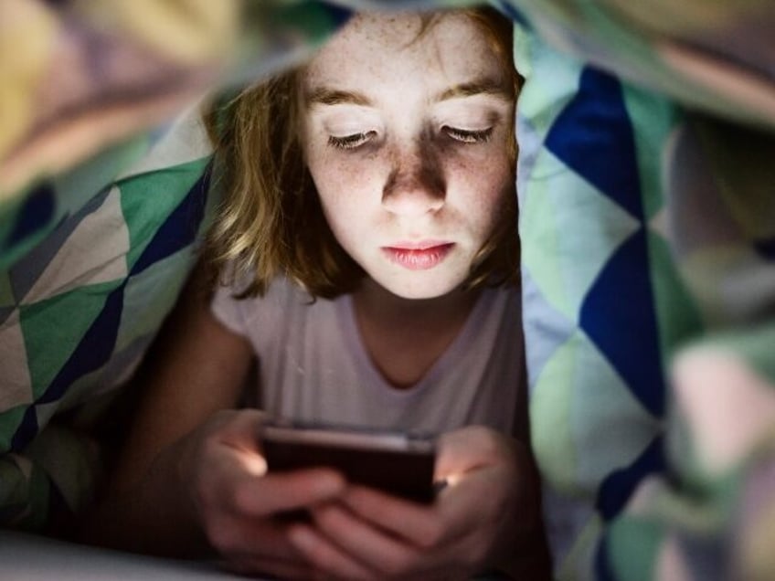 A sad girl doom scrolls social media
