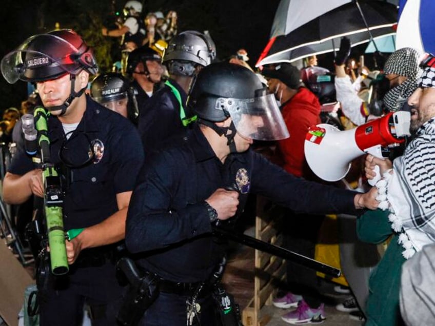 TOPSHOT - Police react while pro-Palestinian students stand their ground after police brea