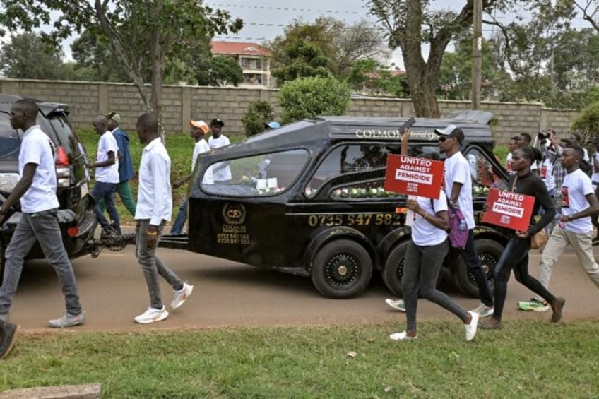 Anti-femicide marchers walk alongside a hearse carrying the body of murdered Olympian Rebe