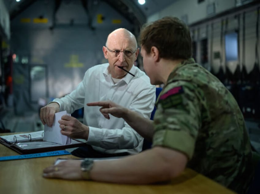 IN AIR - FEBRUARY 19: Britain's Defence Secretary John Healey (L) speaks with a membe