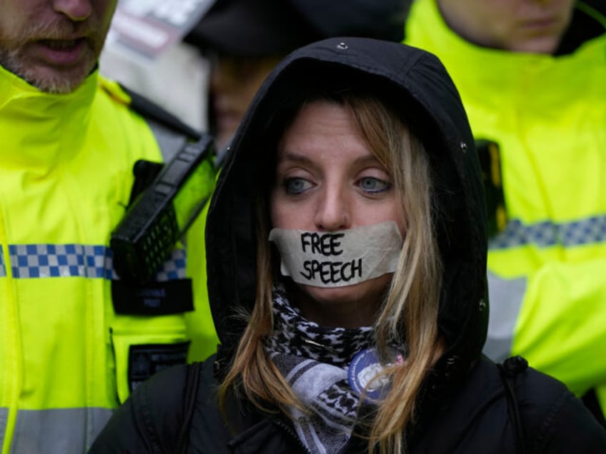 A protester stands outside the Royal Courts of Justice in London, Wednesday, Feb. 21, 2024