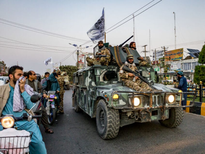 A convoy of Taliban security personnel is seen moving along the streets as they celebrate
