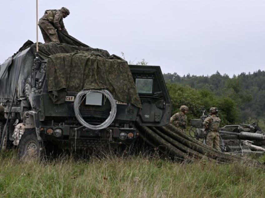 US soldiers of an artillery unit camouflage a vehicle during the NATO exercise 'Saber Junction 23' at the Hohenfels trainings area, southern Germany, on September 14, 2023. More than 4.000 soldiers from the U.S. Army, 14 NATO allies and partners are practicing in the exercise 'Saber Junction 23' until September …