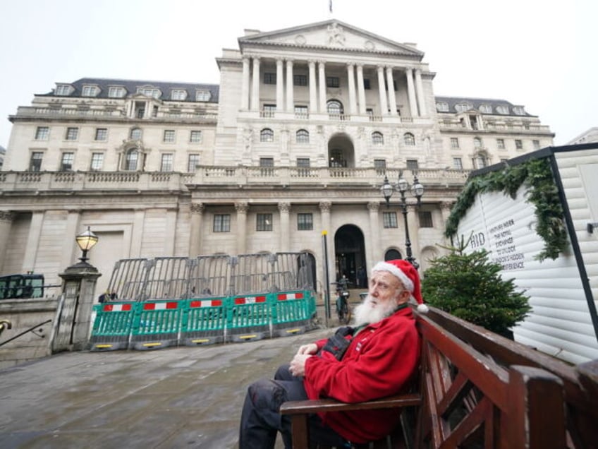 Gerard White, wearing a Santa hat and waiting for his wife to finish work, sitting outside the Bank of England in London which is expected to hold interest rates for the third time in a row, as fresh data has pointed towards potential cracks in the economy. Picture date: Thursday …