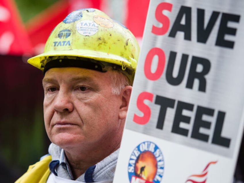 A steel worker holds a placard as he takes part in a protest march through central London on May 25, 2016. Britain's business minister Sajid Javid met Tata Steel bosses in Mumbai ahead of a crunch board meeting on Wednesday expected to discuss potential buyers for its loss-making UK assets. …