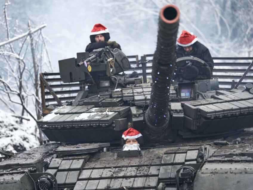 BAKHMUT REGION, UKRAINE - DECEMBER 24: The tank crew in a Christmas outfit goes to perform a combat mission. The press service of the 28th brigade of the Armed Forces of Ukraine records a festive Christmas greeting. The T-64 battle tank was wrapped in a garland and a crew of …