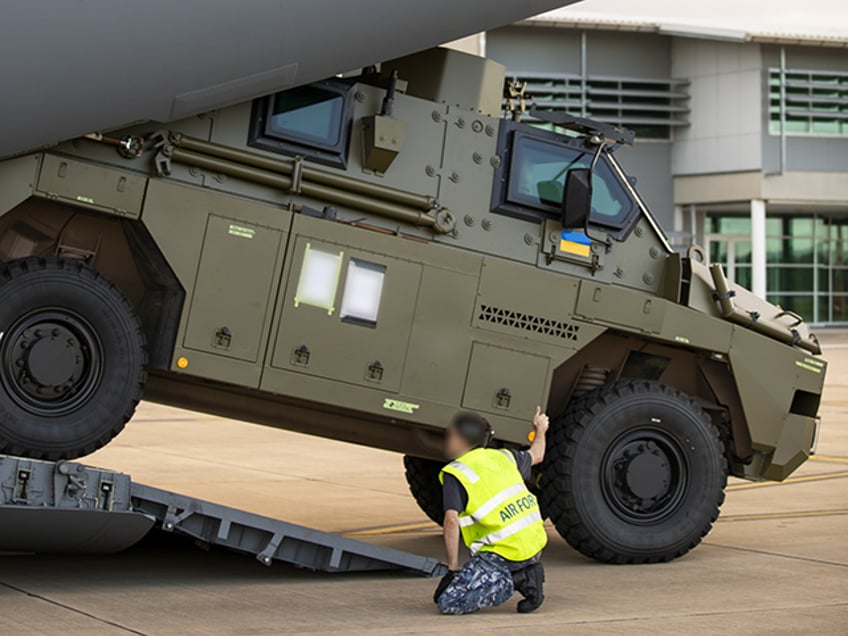 A Royal Australian Air Force air movements operator from No. 23 Squadron guides a Bushmaster protected mobility vehicle bound for Ukraine onto a C-17A Globemaster III aircraft at RAAF Base Amberley, Queensland. *** Local Caption *** The Australian Government has provided further support to the Government of Ukraine by gifting 20 Bushmaster Protected Mobility Vehicles, including two ambulance variants, to aid the Government of Ukraines response to Russias unrelenting and illegal aggression. Australias response follows a direct request from President Zelenskyy during his address to a joint sitting of the Parliament of Australia on 31 March 2022. The Bushmaster Protected Mobility Vehicle was built in Australia to provide protected mobility transport, safely moving soldiers to a battle area prior to dismounting for close combat. The Bushmaster Protected Mobility Vehicle is well suited to provide protection to the Ukrainian Armed Forces soldiers and Ukrainian civilians against mines and improvised explosive devices, shrapnel from artillery and small arms fire. The vehicles have been painted olive green to suit the operating environment. Additionally, a Ukrainian flag is painted on either side with the words United with Ukraine stencilled in English and Ukrainian to acknowledge our commitment and support to the Government and people of Ukraine. The ambulances will have the traditional red cross emblem. The Bushmaster Protected Mobility Vehicles will be fitted with radios, a global positioning system and additional bolt-on armour increasing their protection.