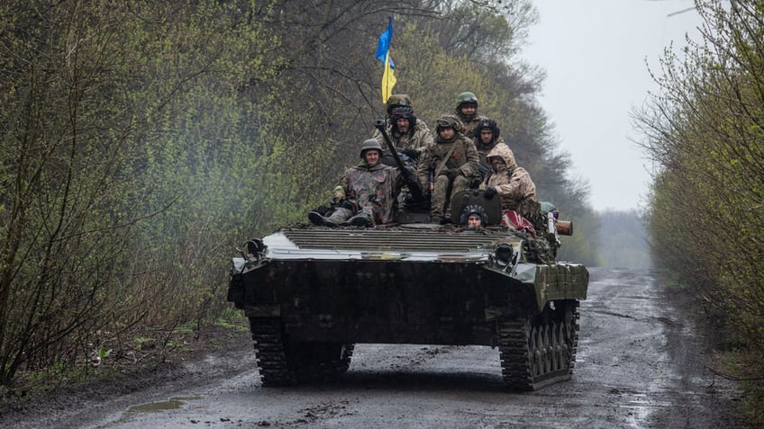 Ukraine servicemen ride a fighting vehicle amid the war