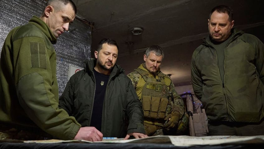 Volodymyr Zelenskyy looking at battleground plans with military leaders