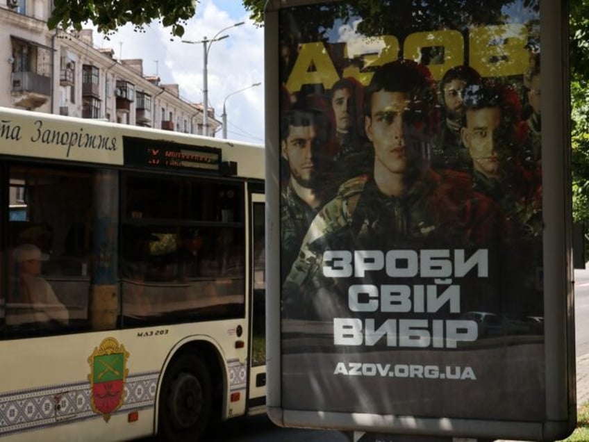 ZAPORIZHZHIA, UKRAINE - 2024/06/27: People pass in the trolley bus by the recruitment post