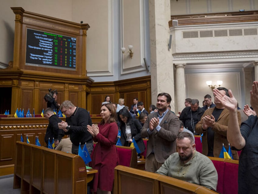 Ukrainian lawmakers react after the successful vote to ratify a landmark minerals deal sig