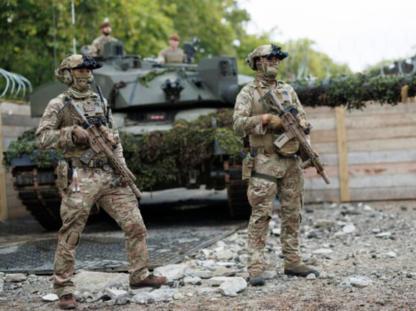 Members of the British Army are seen here with a Challenger 2 Main Battle Tank in the back