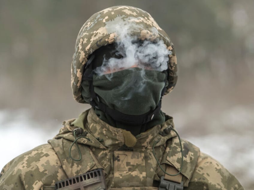 A member of the Siberian Battalion of the International Legion of the Armed Forces of Ukraine is smoking during military exercises at a training ground in the north of Ukraine on December 13, 2023. (Photo by Maxym Marusenko/NurPhoto via Getty Images)