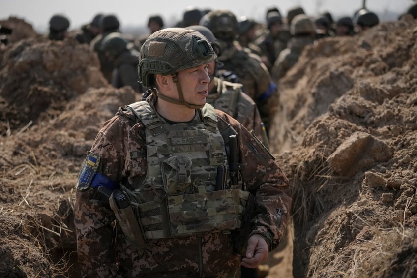 Col. Gen. Oleksandr Syrskyi, top military commander in charge of the defense of the Ukrainian capital, walks in a trench at a position north of the capital Kyiv, Ukraine, Tuesday, March 29, 2022. The first face-to-face talks in two weeks between Russia and Ukraine began Tuesday in Turkey, raising flickering hopes there could be progress toward ending a war that has ground into a bloody campaign of attrition. (AP Photo/Vadim Ghirda)