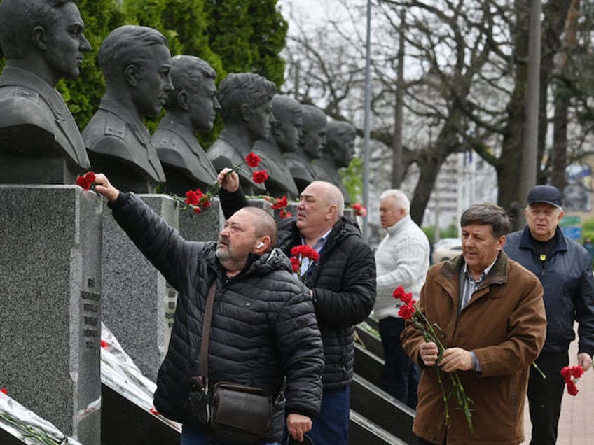 Liquidators of Chernobyl nuclear power plant catastrophe, lay flowers during the commemoration of the victims of the Chernobyl nuclear disaster on the 38th anniversary of the world's worst nuclear accident, at the Chernobyl memorial in Kyiv on April 26, 2024. (Photo by Sergei SUPINSKY / AFP)