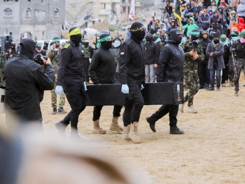 Palestinian militants carry one of the four coffins during the handover of the bodies of f