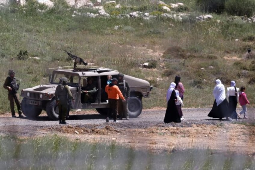 Israeli soldiers stop a Syrian Druze family, who fled sectarian violence outside Damascus,