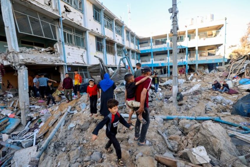 Palestinians check the destruction at a UNRWA school following an Israeli strike on May 7,